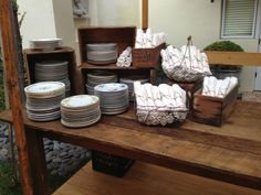 there are many plates and bowls on the wooden table with it's trays