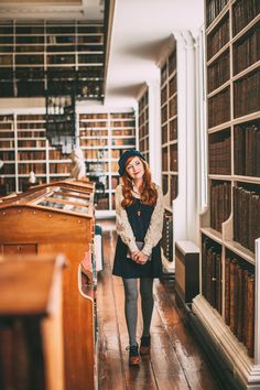 a woman standing in the middle of a library