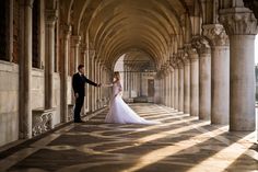 a bride and groom holding hands in an old building