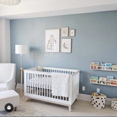 a baby's room with blue walls, white furniture and pictures on the wall