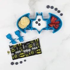 the batman waffle maker is next to berries and blueberries