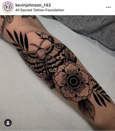 a woman's arm with black and white tattoos on it