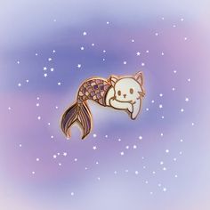 a gold colored brooch with a white cat sleeping on it's back and stars in the background