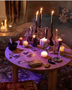 a table with candles and pictures on it in the middle of a living room filled with furniture