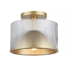 a flush light fixture with pleated glass on the bottom and gold trimmings