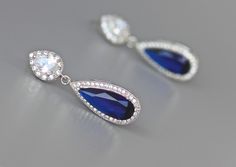 "Would you love to sparkle even brighter on your special day? Looking for your something Blue? Gorgeous bridal earrings have been created using a long sapphire blue crystal in a cz halo and are completed by your choice of earpost. Perfect for the Mother of the bride. Style #1~ Art Deco-inspired earpost. CZ crystals studded in a double swirl. Style #2~ Teardrop Earpost -pearl CZ crystal in a halo of smaller crystals. Post back Style #3~ Smaller Teardrop earpost, inverted pear crystal with a halo Blue Drop Bridal Earrings, Sapphire Pear-shaped Earrings For Wedding, Pear-shaped Sapphire Earrings For Wedding, Blue Teardrop Bridal Earrings For Anniversary, Sapphire Teardrop Earrings For Wedding, Blue Drop Bridal Earrings For Wedding, Blue Cubic Zirconia Bridal Earrings For Wedding, Blue Pear-shaped Wedding Earrings, Blue Sterling Silver Earrings For Wedding