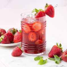 a glass filled with liquid and strawberries