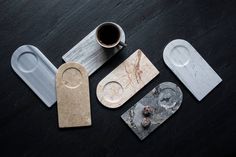 several different shapes and sizes of coasters on a table with a cup of coffee