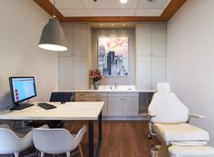 an office with two white chairs and a computer desk