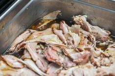 meat is being cooked in a large metal pan