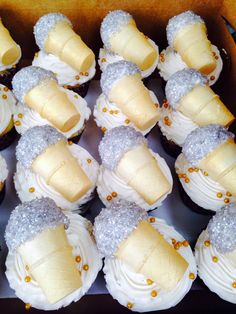 a box filled with cupcakes covered in white frosting and banana peels