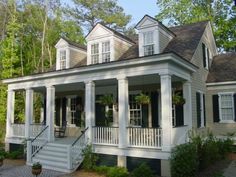 a white house with black shutters on the front porch