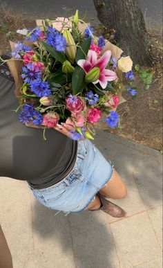 a woman is holding a bouquet of flowers