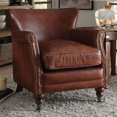 a brown leather chair sitting on top of a rug