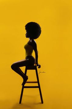 a woman sitting on top of a wooden chair in front of a yellow background,