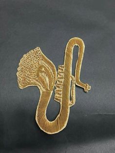 a gold snake brooch sitting on top of a black surface