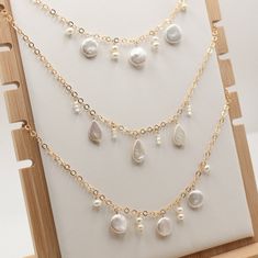 Delicate and dazzling, this 16-inch necklace features a trio of teardrop freshwater pearls, interspersed with shimmering 3mm crystals. The elegant design captures the light beautifully, adding a touch of sparkle to any outfit. Perfect for both everyday wear and special occasions, this piece is a timeless addition to your jewelry collection. 14 K. Gold filled Freshwater Pearls Austrian Crystals Pictured with The Coastal Chain Gold Crystal Necklaces With Faceted Beads For Wedding, Elegant Gold Crystal Necklace With Polished Beads, Elegant Faceted Dangle Crystal Necklaces, Elegant Gold Crystal Necklace With Pearl Drop, Elegant Gold Pearl Crystal Necklace, 16 Inch Necklace, Austrian Crystal, Bridal Shop, Chain Earrings