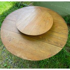 two wooden plates sitting on top of each other in the grass next to a building