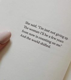 a person holding an open book with the words she said, i'm just not giving up