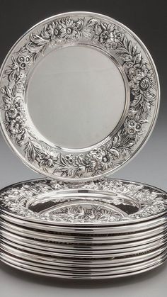 a stack of silver plates sitting on top of each other