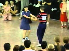 two people dancing on a dance floor in front of an audience