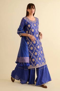 Blue straight kurta with gota embroidery in floral pattern and round neckline. Paired with crushed sharara and tassel dupatta.
Components: 3
Pattern: Embroidery
Type Of Work: Gota, floral
Neckline: Round
Sleeve Type: Three quarter
Fabric: Kurta: Chanderi, Sharara: Mulmul, Dupatta: Chanderi
Color: Blue
Other Details: 
Tiered sharara
Tassel bordered dupatta
Gota embroidered cutwork border
Occasion: Puja - Aza Fashions Crushed Sharara, Tassel Dupatta, Gota Embroidery, Blue Kurta, Types Of Work, Straight Kurta, Sharara Set, Pattern Embroidery, Fashion App