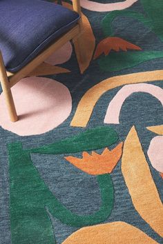 a blue chair sitting on top of a colorful rug