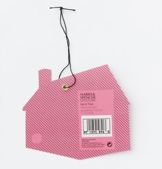 a pink house shaped gift tag hanging from a string