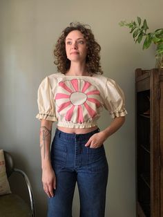 "* Manitou Handmade * Dresden Plate appliqué crop blouse with puff sleeves and elastic waist. * Shoulders 15.5\" Chest 35\" Length 16.5\" Waist 24\" to 31\" PLEASE READ! *MEASUREMENTS* All items are measured while laying flat and unstretched. For clothing: chest, waist, hip and thigh measurements should be multiplied by two. All measurements are in inches. *VINTAGE CONDITION* Vintage goods may show signs of wear and age. We always indicate and/or show in pictures any major flaws or blemishes, but will not always mention small flaws, such as pinpoint sized spots or holes. If you are concerned about a particular item's condition, please message us. All of our pieces are pre-owned. We use a natural detergent to wash all our textiles when necessary (with a few exceptions such as rugs/nail apro Summer Puff Sleeve Top With Patchwork, Spring Patchwork Puff Sleeve Tops, Spring Puff Sleeve Patchwork Tops, Cotton Puff Sleeve Crop Top With Ruffles, Fitted Cotton Cropped Puff Sleeve Top, Cotton Crop Top With Puff Sleeves And Ruffles, Cotton Crop Top With Elastic Waistband, Spring Cropped Blouse With Elastic Sleeves, Spring Crop Top With Blouson Sleeves