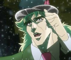 a man with green hair wearing a hat and holding his hand up to his face