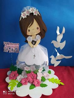 a cake made to look like a bride with flowers on the bottom and doves in the background