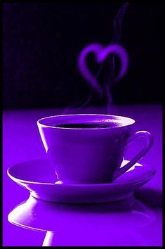 a purple coffee cup and saucer with a heart shaped steam rising out of it