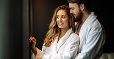 a man and woman in bathrobes standing next to each other