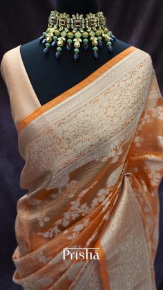 Orange crushed Banarasi tissue silk saree with light gold zari jaal weaving all over the body, this easy to drape, light weight saree has a beautiful floral pallu and border.  Blouse: Orange brocade material [unstitched] Code: AH008 Please note there may be slight colour variation due to lighting. Orange Tussar Silk Saree With Zari Weaving, Orange Tussar Silk Pre-draped Saree With Zari Weaving, Elegant Saree Blouse Piece With Weaving Work, Gold Banarasi Silk Saree For Transitional Season, Transitional Gold Banarasi Silk Saree, Elegant Orange Katan Silk Saree, Elegant Orange Raw Silk Saree, Gold Dupatta With Weaving Work, Tissue Silk Saree With Traditional Weaving Work