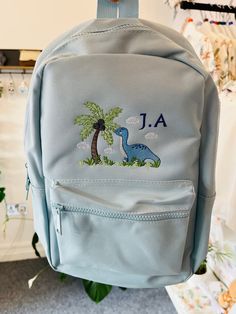 Dino backpack 🎒  Lots of colours available and loads of different designs. Any design requests please message and I'll happily accommodate.  These backpacks are fantastic as a changing bag, starting nursery, starting school. Adjustable straps and handy front pocket.  Designs are embroidered onto the front of the bag in any style/colour scheme of your choice. Child's name can be added. This embroidery is carefully crafted using the best quality threads 🧵 Time is taken to give you the very best Student Bags For Back To School, Softback Bags For Students End Of School Year, Student Softback Bags For End Of School Year, Cute School Backpack Satchel, Cute Standard Backpack For Back To School, Cute School Satchel Backpack, Cute Satchel Backpack For School, Softback Bag For Back To School, Back To School Softback Bags