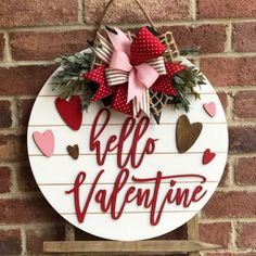 a sign that says hello valentine hanging on a brick wall