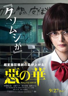 a woman with glasses and a bow tie in front of a poster for the movie