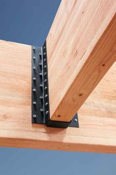 a piece of wood that is attached to the side of a wooden structure with metal brackets