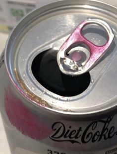 a can of diet coke with a pink flip top opener on the lid and bottom