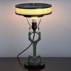 a lamp that is sitting on top of a table next to a light bulb and some wires