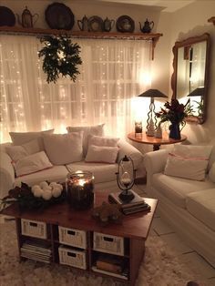 a living room filled with white furniture and lots of lights on the window sill