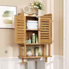 an open wooden cabinet with towels and other bathroom items on the shelf next to it