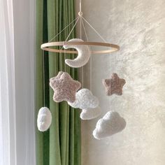 a crocheted star and moon mobile hanging from the ceiling in front of a window