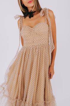 Dazzle in this champagne colored dress with a tulle overlay and playful black polkadots. Featuring a sweetheart neckline, ruching on the bodice, and a smocked panel on the back for the perfect fit. Complete with a silver zipper in the back and a tiered skirt, this midi dress is sure to turn heads. Adjustable tie straps add a fun touch. Details Champagne colored dress Tulle overlay Black polkadots Sweetheart neckline Ruching on bodice Padded cups Smocked panel on back Silver zipper in back Tier o Beige Party Dress With Ruched Bodice, Party Dress With Ruched Bodice In Beige, Beige Dresses With Ruched Bodice For Party, Summer Polka Dot Dress With Sweetheart Neckline, Fitted Polka Dot Dress With Sweetheart Neckline, Spring Polka Dot Tulle Dress, Summer Polka Dot Dress For Wedding, Summer Wedding Polka Dot Dress, Elegant Polka Dot Dress With Sweetheart Neckline