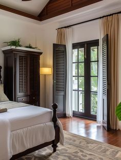 a bed sitting in a bedroom next to a window with shutters on both sides