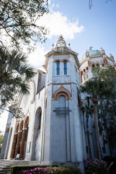 an old building with palm trees in front of it and stairs leading up to the entrance