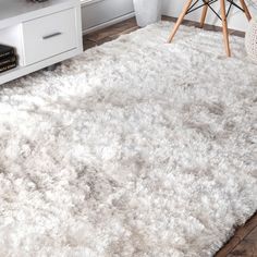 a white area rug in the corner of a room