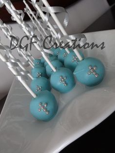 some blue cake pops are on a white plate