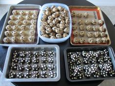 four trays filled with different types of cookies on top of a black table next to each other