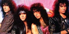 the band kiss posing in front of a pink background